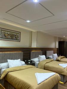 una habitación con tres camas en una habitación en Golden pyramids temple view INN, en El Cairo