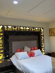 Una cama con globos rojos encima. en Golden pyramids temple view INN, en El Cairo