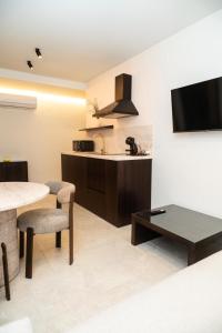 Una sala de estar con una mesa y una cocina. en Apartamentos Máximo, en Mérida