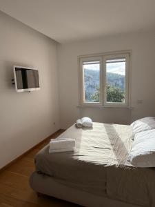 a bedroom with a large bed with a television on the wall at White Stylish Apartment 4 in Vico Equense