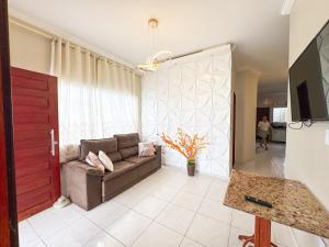 a living room with a couch and a red door at Casa victória Régia in Camocim