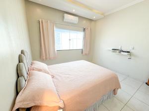 a bedroom with a large bed with a window at Casa victória Régia in Camocim