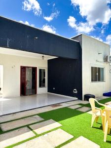 a black and white house with a patio and grass at Casa victória Régia in Camocim