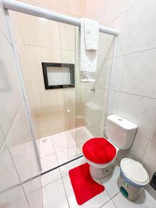 a bathroom with a shower and a toilet with a red seat at Casa victória Régia in Camocim +21 photos