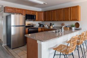 a kitchen with a stainless steel refrigerator and wooden cabinets at Spacious 3 Bed Condo Near ETSU in Johnson City
