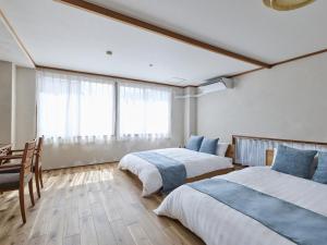 a bedroom with two beds and a table and chairs at LIVE HEART House in Nara