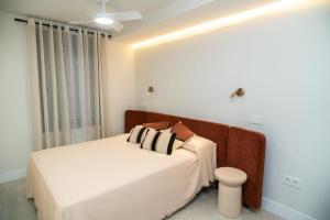 un dormitorio con una cama y un sofá en Apartamentos Máximo, en Mérida