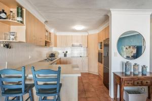 a kitchen with two blue chairs at a counter at Wintersview 3 in Lennox Head