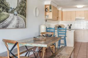 a kitchen and dining room with a wooden table and chairs at Wintersview 3 in Lennox Head