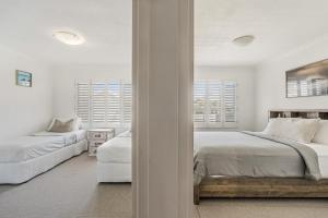 a white bedroom with two beds and a couch at Wintersview 3 in Lennox Head +9 photos