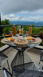 a table with plates of food on a balcony at La Font Ecolodge in Buenavista