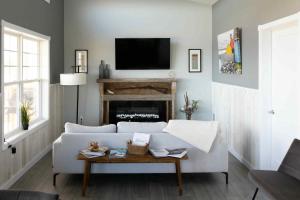 ein Wohnzimmer mit einer weißen Couch und einem Kamin in der Unterkunft Down East Cabins in Tracadie