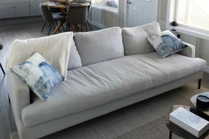 ein weißes Sofa mit Kissen darauf im Wohnzimmer in der Unterkunft Down East Cabins in Tracadie