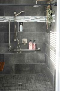 ein Badezimmer mit einer Dusche mit grauen Fliesen in der Unterkunft Down East Cabins in Tracadie + 9 Fotos