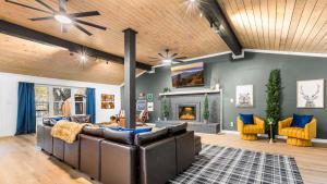 Elle comprend un salon doté d'un mobilier en cuir et d'une cheminée. dans l'établissement Lodge-Style Home Near Gatlinburg w Theater Hot Tub Game Room Evergreen Escape by AvantStay, à Pittman Center