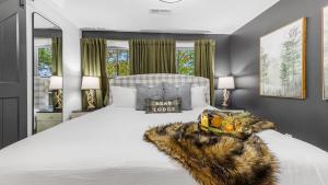 une chambre avec un grand lit blanc avec une couverture en fourrure dans l'établissement Lodge-Style Home Near Gatlinburg w Theater Hot Tub Game Room Evergreen Escape by AvantStay, à Pittman Center 47 autres photos