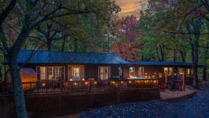 une maison dans les bois avec des lumières dessus dans l'établissement Lodge-Style Home Near Gatlinburg w Theater Hot Tub Game Room Evergreen Escape by AvantStay, à Pittman Center