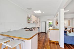 a kitchen with white cabinets and a counter top at Nonna and Pops in Mylestom +15 photos