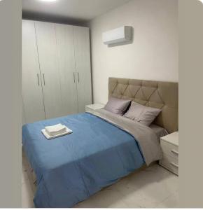 Un dormitorio con una cama grande con una manta azul. en Qawra Seaside Birch Leaf, en St Paul's Bay