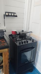 a black stove with two pots on top of it at EcoChalé de Arraial in Arraial do Cabo