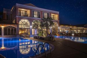a large building with a swimming pool at night at Villa Plaza Boutique Hotel & Spa in Prešov
