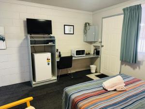 Hatton Vale哈顿谷汽车旅馆的客房设有一张床、一张书桌和电视
