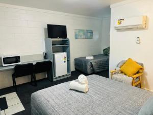 Hatton Vale哈顿谷汽车旅馆的客房设有一张床、一张书桌和电视