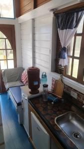 a kitchen with a sink and a counter with a stove at EcoChalé de Arraial in Arraial do Cabo