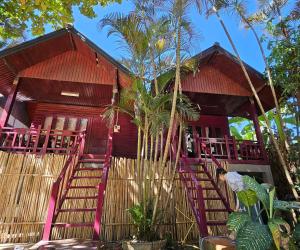 a red house with a staircase in front of it at west water hostel in Vang Vieng +26 photos