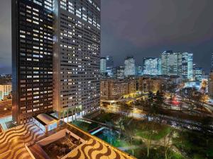 uma vista de uma cidade à noite com edifícios em Mercure Paris La Défense em Courbevoie