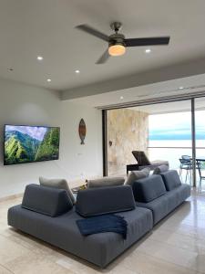 ein Wohnzimmer mit einer Couch und einem Deckenventilator in der Unterkunft Arena Bca in La Cruz de Huanacaxtle