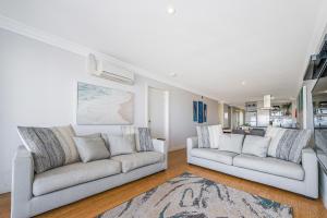 a living room with two white couches and a rug at Oceans Waves - Luxury Apartment with ocean views in Lancelin