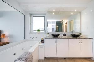 a bathroom with two sinks and a large mirror at Oceans Waves - Luxury Apartment with ocean views in Lancelin +16 photos