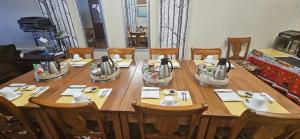 a large wooden table with wooden chairs and a table at La Casa Guesthouse in Punta Arenas