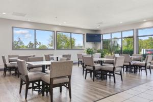 een eetkamer met tafels en stoelen en ramen bij Days Inn & Suites by Wyndham Wynne in Wynne