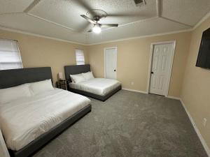 a bedroom with two beds and a ceiling fan at NEW Grand Escape For Large Families and Groups in Garland