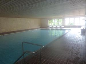 ein großer Pool mit Stühlen in einem Gebäude in der Unterkunft Ferienpark Oberallgäu Ferienwohnung in Missen-Wilhams