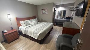 a hotel room with a bed and a bathroom at Colonial Inn in Shawnee