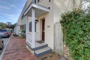 a white house with a door and stairs on a sidewalk at Coach`s Corner in Savannah