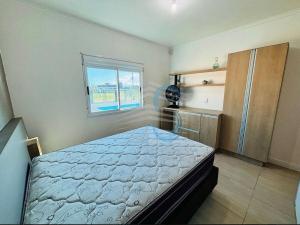 a bedroom with a bed and a window at Casa com Piscina in Arroio do Sal +24 photos