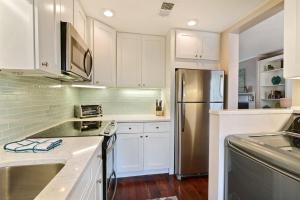 a kitchen with white cabinets and a stainless steel refrigerator at Coach`s Corner in Savannah