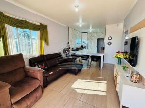 a living room with a couch and a table at Casa com Piscina in Arroio do Sal