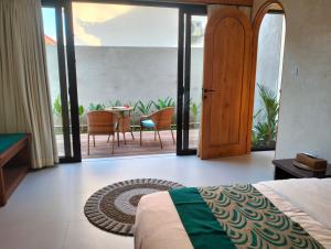 a bedroom with a bed and a table and chairs at Villa Puri Mesari Amed in Amed +6 photos