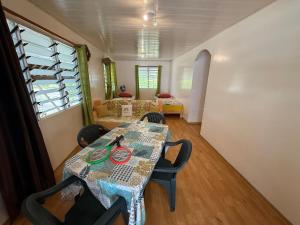 a room with a table and chairs and a couch at Chez Aroro Beach House in Avatoru +4 photos