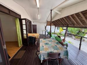 a dining room with a table and chairs on a deck at Chez Aroro Beach House in Avatoru