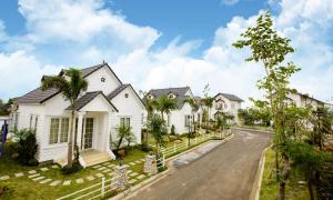 a row of white houses on a street at Vườn Vua Resort & Villas in Ðồng Phú