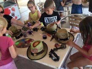 un groupe d'enfants jouant avec des chapeaux sur une table dans l'établissement Mobil-Home Confortable 3 Chambres avec Terrasse - API-1-52-399, à Saint-Sornin