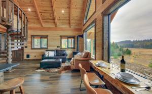 una baita di tronchi con soggiorno dotato di tavolo e sedie di Hidden Valley Haven a Sandpoint