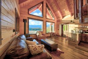 un soggiorno con divano in pelle in una cabina di Hidden Valley Haven a Sandpoint