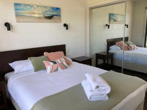 Un dormitorio con una cama con toallas. en The Anchorage Bermagui, en Bermagui